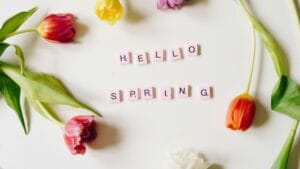Fiori colorati con scritta 'Hello Spring'.