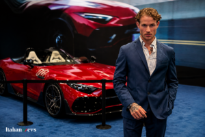 Giorgio Torelli durante un evento esclusivo nel settore automotive di lusso a Dubai, davanti a una supercar rossa in un contesto premium.