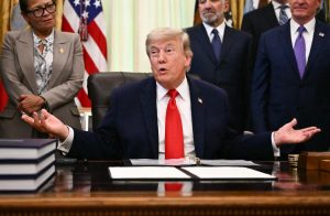 Trump firma accordo con espressione sorpresa