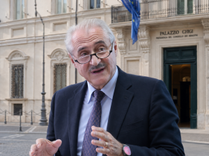 Uomo parla davanti a Palazzo Chigi.
