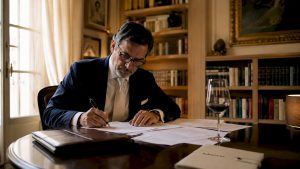 Un diplomatico italiano è impegnato nella lettura di documenti nel suo ufficio istituzionale.