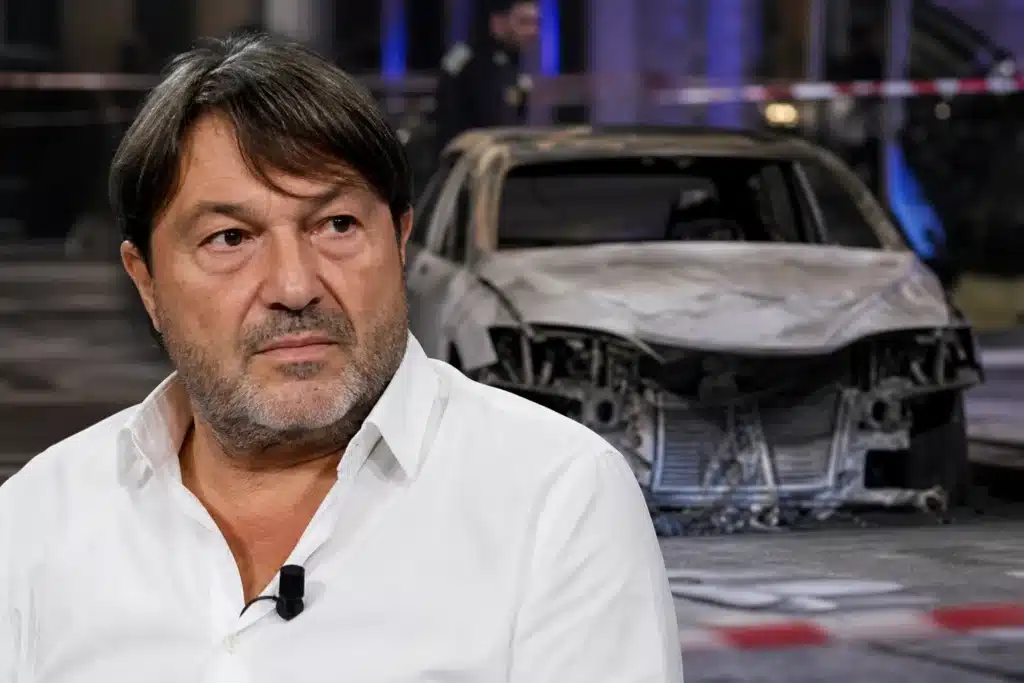 Il conduttore Ranucci in primo piano con la foto dell'attentato