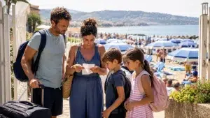 Famiglia in spiaggia con bagagli.