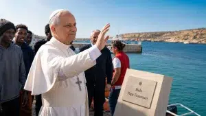 Papa Francesco saluta i migranti.